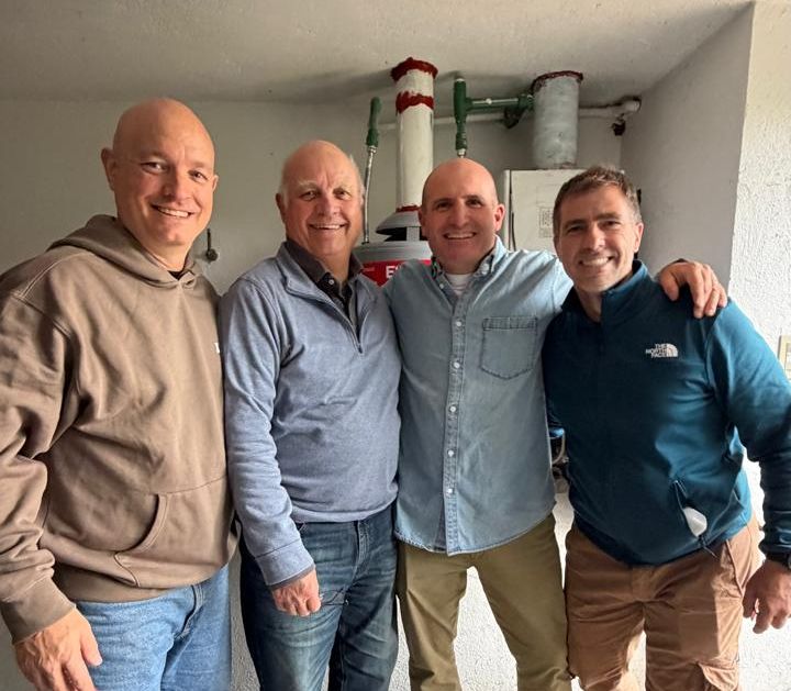 Cuatro integrantes del equipo sonriendo después de un trabajo en una casa